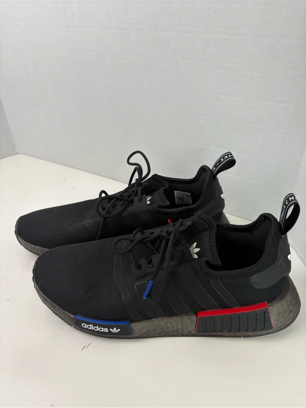 Adidas NMD_R1 Black Sneakers with Red and Blue Accents